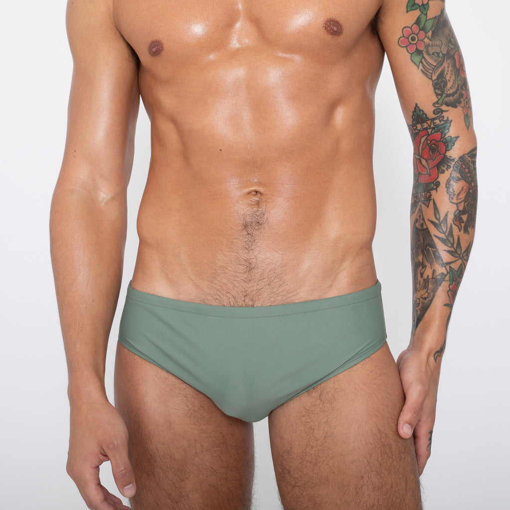 Man wearing light green swim brief. Front view.