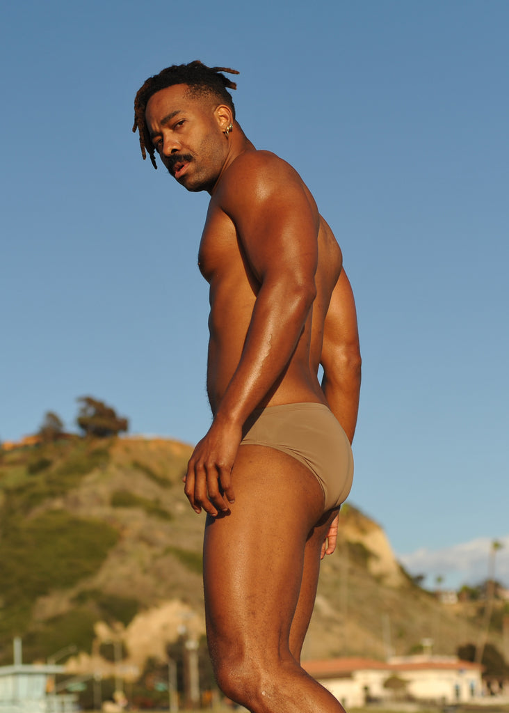 Image of model wearing light brown swim brief.