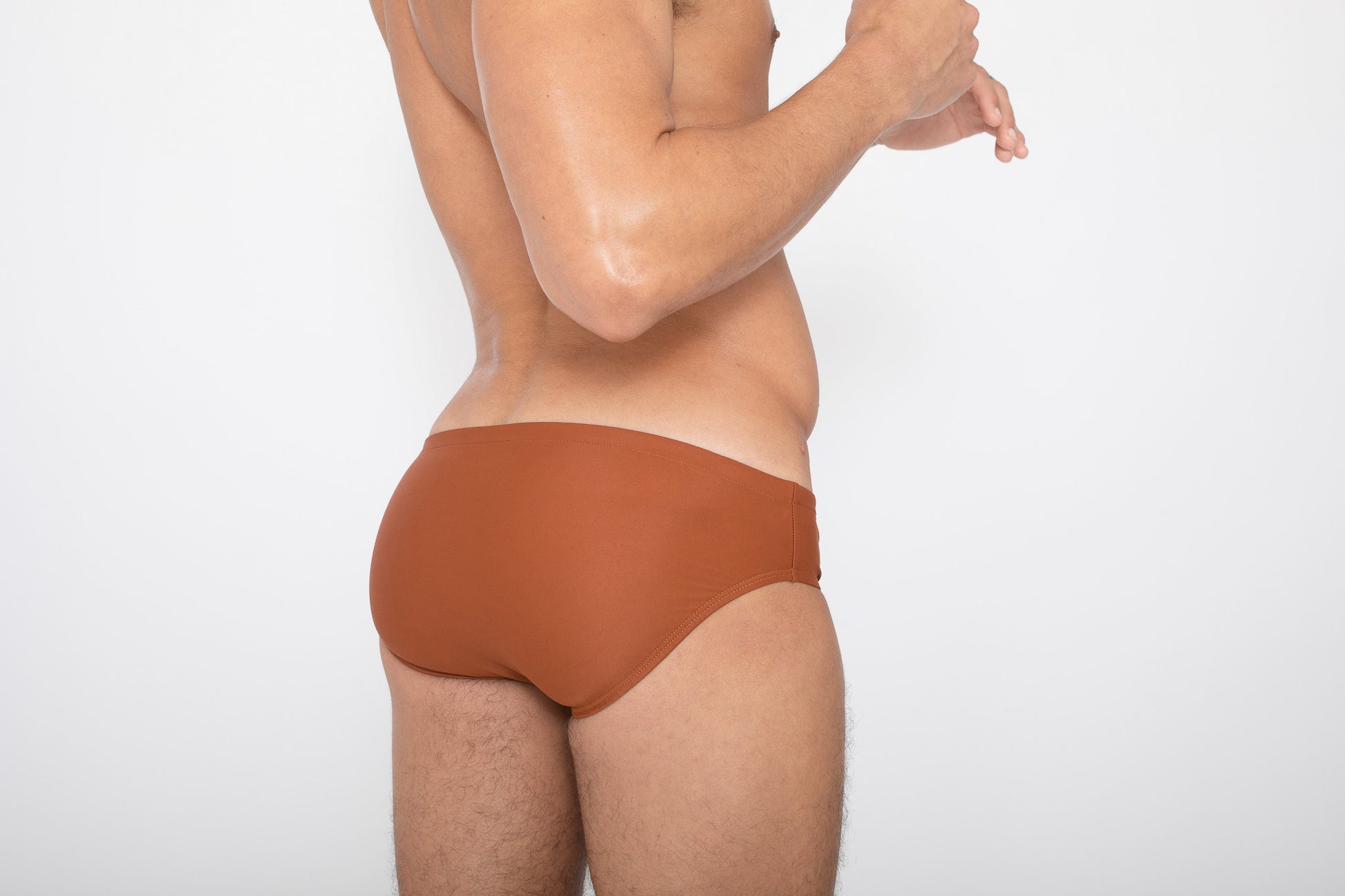 Model wearing terracotta colored brief